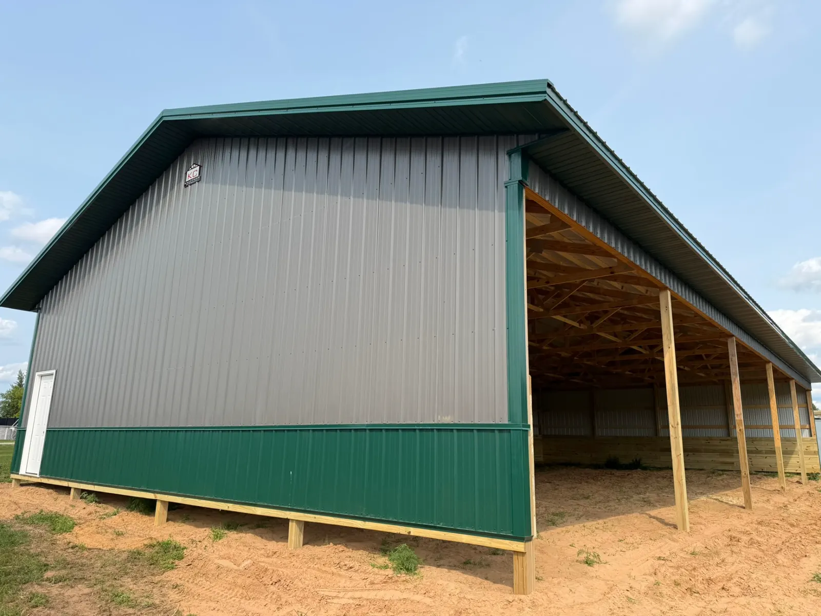 Horse barn with open run-in side and green wainscot, built by Kauffman Construction in Wisconsin