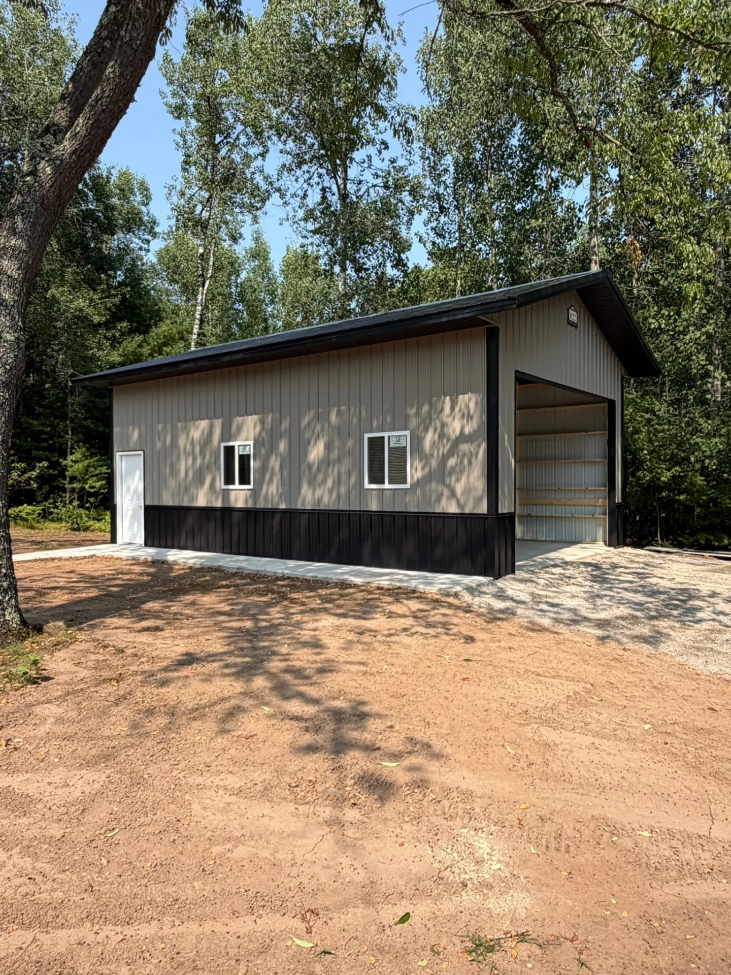 Tan pole garage with black wainscot and roof, built by Kauffman Construction in Wisconsin