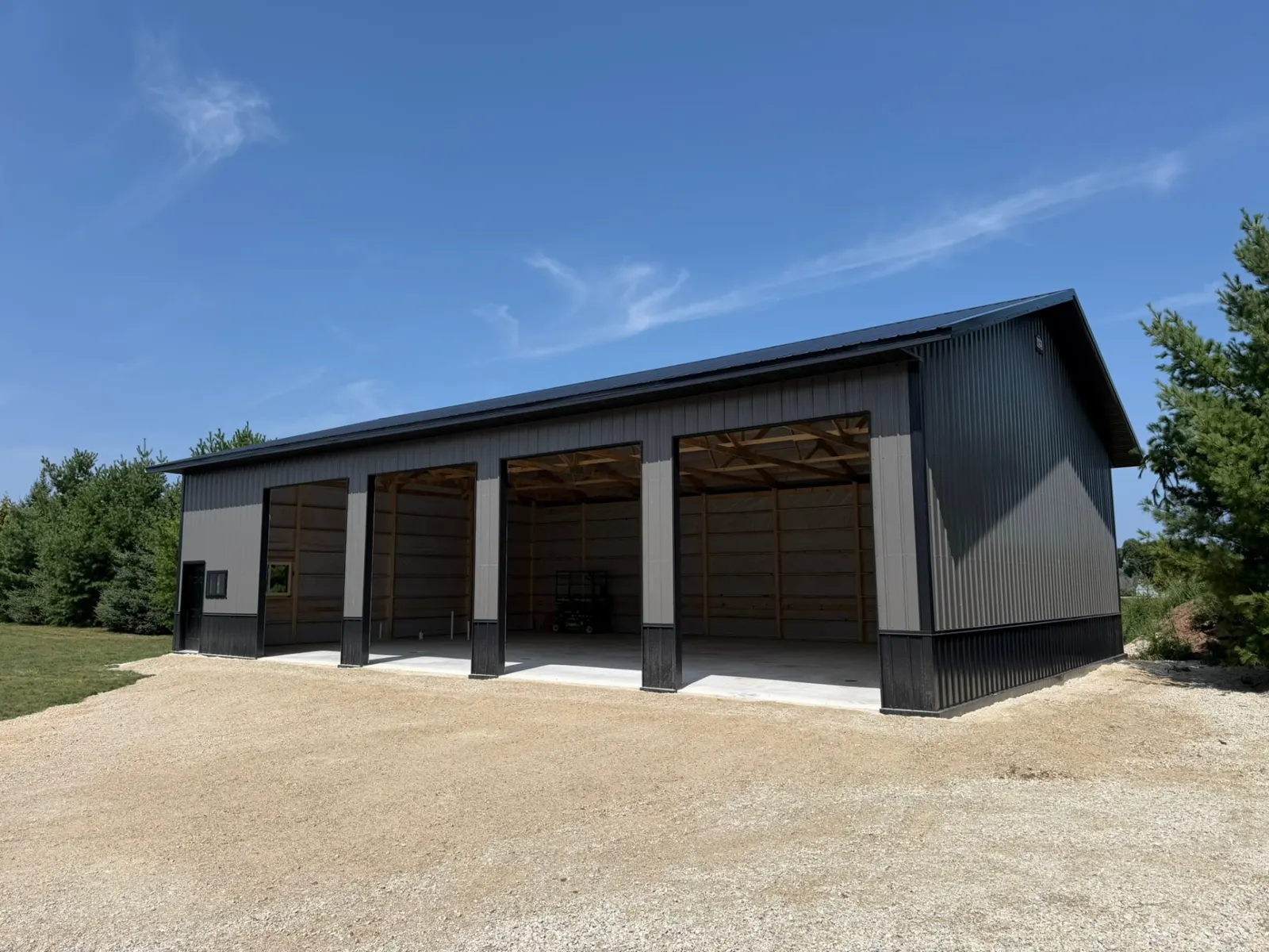 Four-bay pole building machine shed with black trim, built by Kauffman Construction in Wisconsin