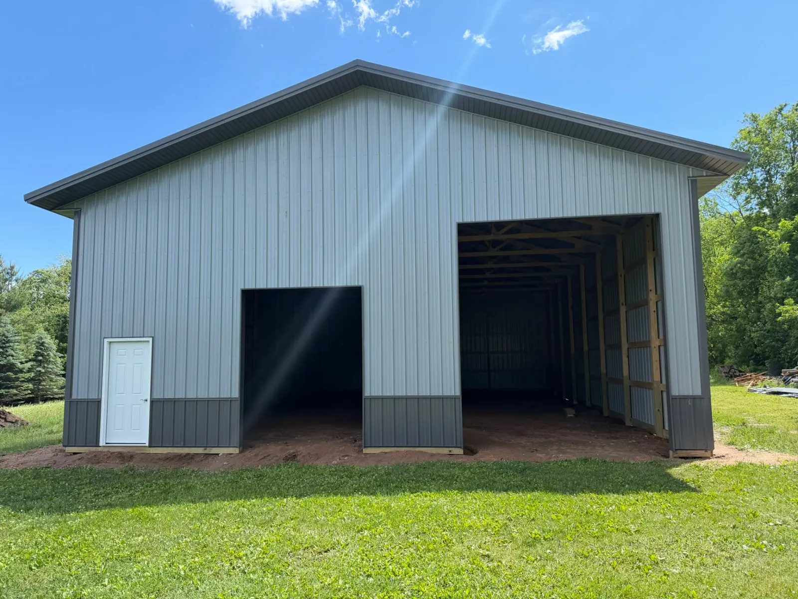 Gray pole barn with two overhead door openings, built by Kauffman Construction in Wisconsin