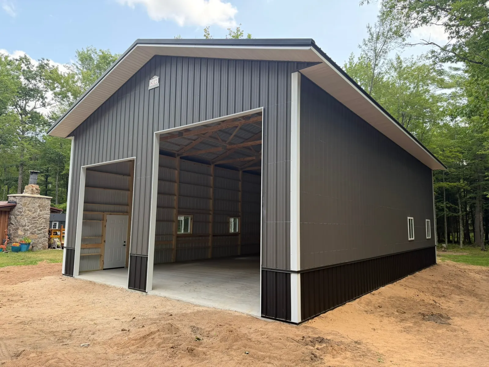 Pole shop with tall overhead door and exposed trusses, built by Kauffman Construction in Wisconsin