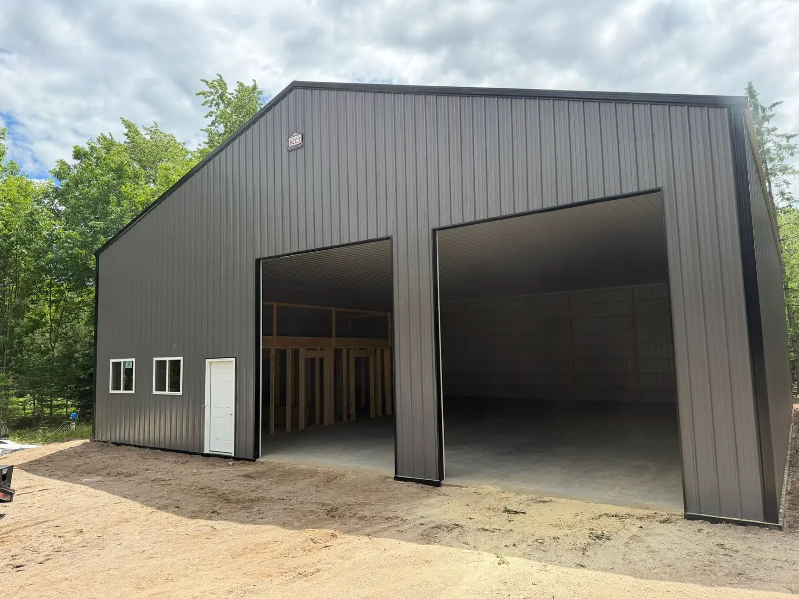Gray pole building with two large overhead door openings, built by Kauffman Construction in Wisconsin