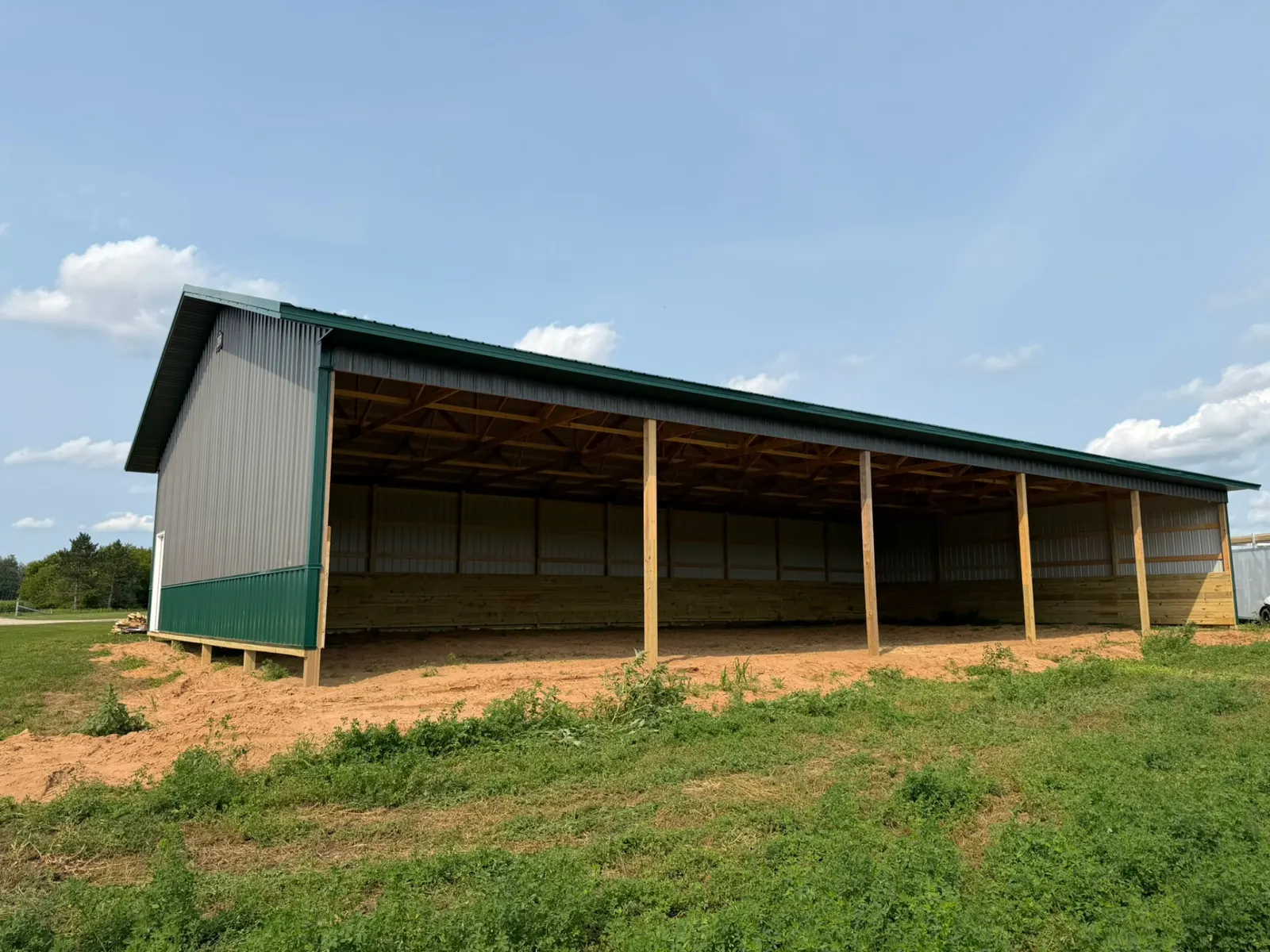 Open-front horse shelter pole barn with green roof, built by Kauffman Construction in Wisconsin
