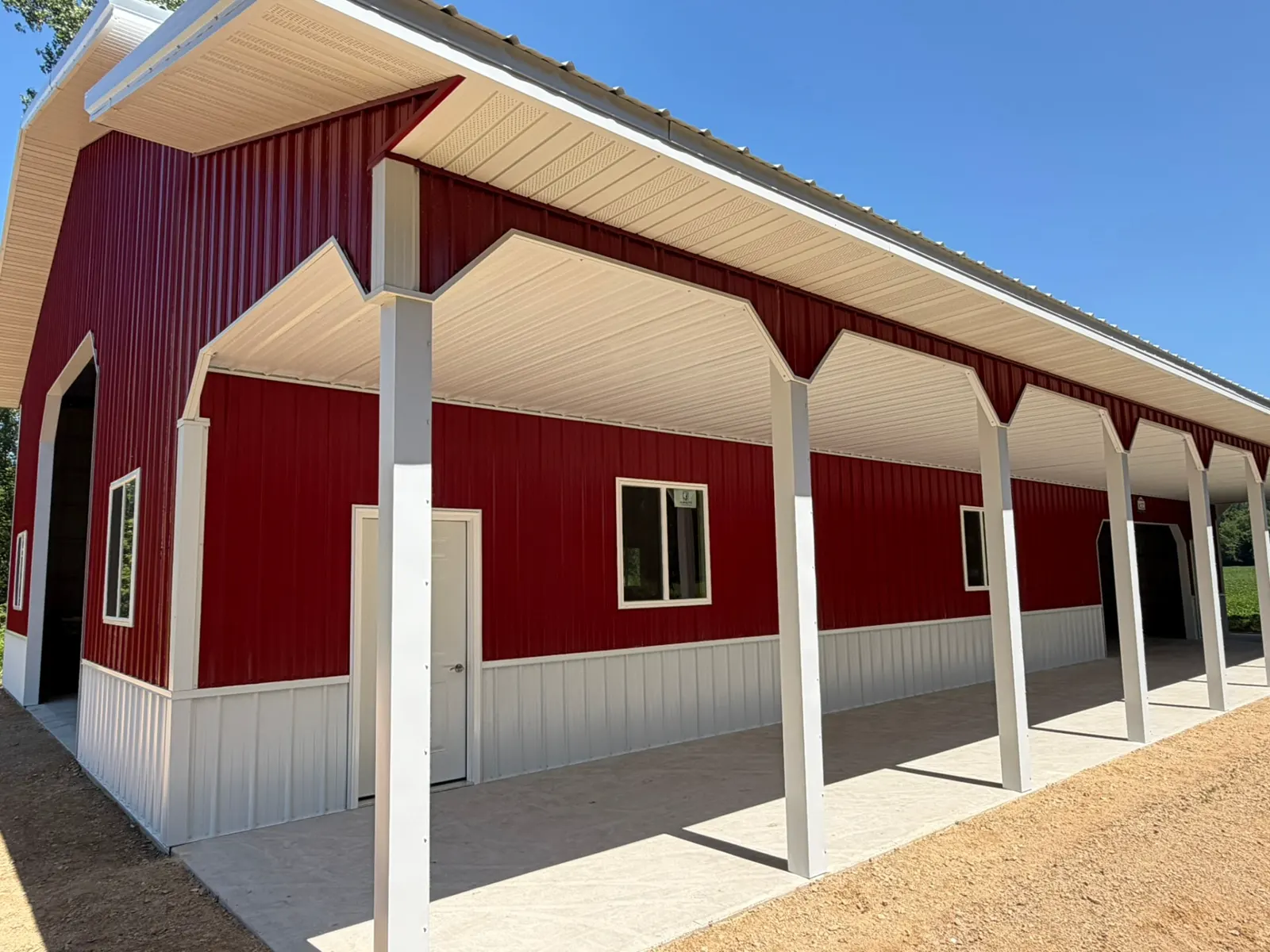 Red pole barn with long covered porch on concrete, built by Kauffman Construction in Wisconsin